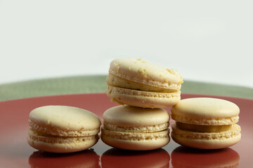 White Macaroons in a red plate with a white and green background