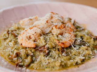 Mushroom risotto with spinach and grilled shrimp under parmesan cheese