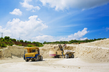 An excavator loads a huge truck with rock. © davit85