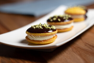 Bouche. Homemade stuffed desserts with pistachio crunches on top.