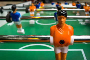Extreme Close-Up of a Player with an Orange Jersey on a Foosball Table