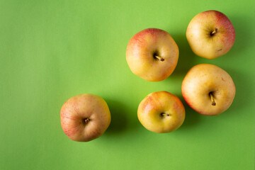 Yellow apples on a green background. Horizontal orientation. View from above.