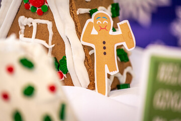 Funny Diorama of a Gingerbread Person Leaning Against a Gingerbread House while Eating their Own Leg
