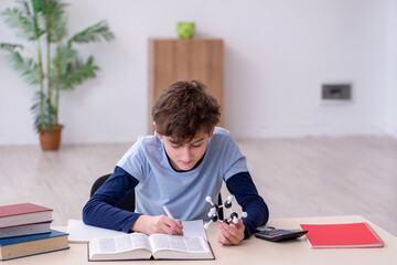 Schoolboy looking at molecular model at home
