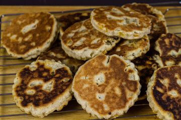 Freshly cooked sugared welshcakes on a cooling rack elevated view.