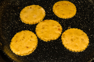 Close up of Welsh cakes cooking on a stove.