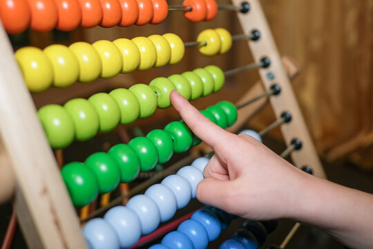 Primary school girl learning math using wood abacus at home,kids son education