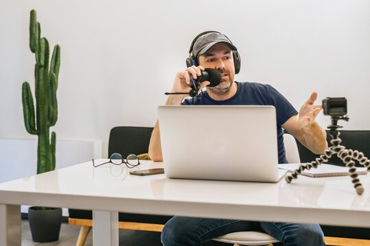 Content creator working online at home. Vloggers with recording equipment and shooting video make a podcast in studio. Blogger filming himself having fun using technology to connect with audiences.