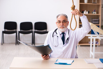 Old male doctor committing suicide at workplace