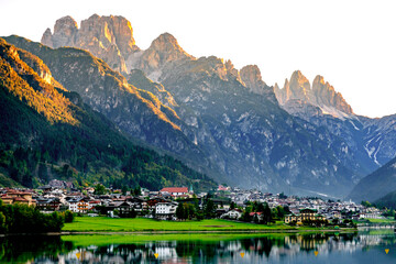 Fototapeta na wymiar A small town on a mountain lake. Alps, Italy.