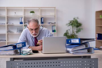 Old male accountant in budget planning concept in the office