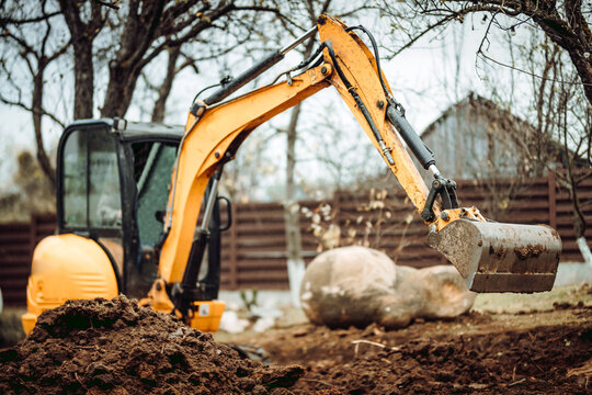 Landscaping works with mini excavator at home construction site. Terrain works