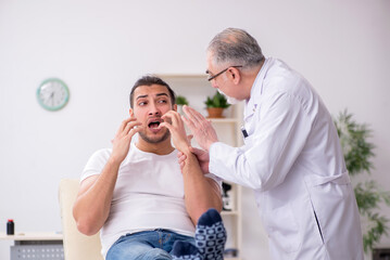 Young man visiting experienced doctor dermatologist