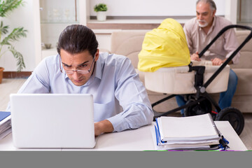 Obraz premium Retired grandfather looking after newborn at home