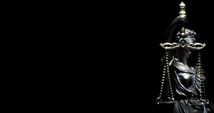 4k Spot Lit Lady Justice Statue Slowly Rotating on Black Background.
