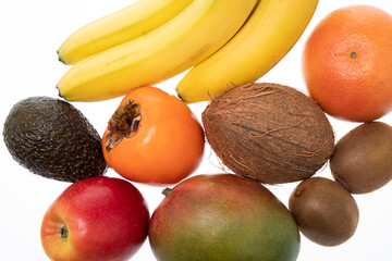 Banana with ripe hurma, avocado, mango, apple and coconut on white