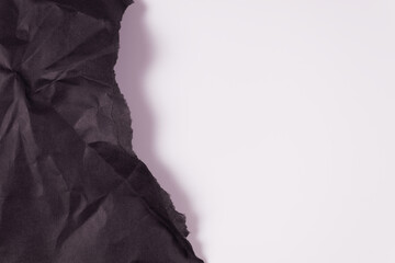 on the left side of the frame, crumpled black solid paper