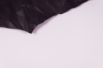 at the top of the frame, a piece of black crumpled paper is visible, torn at the edges