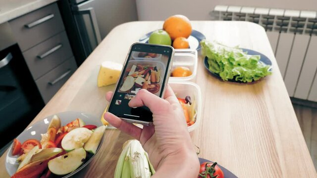 cooking online. healthy food. close-up. top view. Woman blogger taking pictures of vegetarian lunch on smartphone for social media, at home kitchen. culinary vlogging, social networks.
