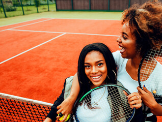 young pretty girlfriends hanging on tennis court, fashion stylish dressed swag, best friends happy...