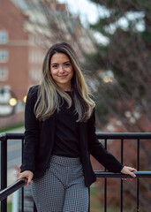 Young business woman leaning on post in urban office