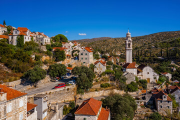 Fototapeta premium Village Lozisca at sunset hour. Island Brac, Croatia. August 2020. Aerial drone view.