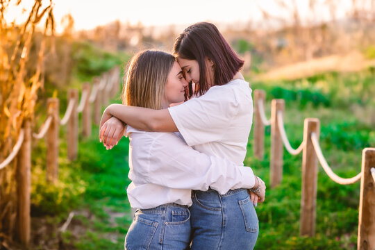 pareja de chicas abrazadas en un camino en el campo en actitud rom&aacute;ntica 