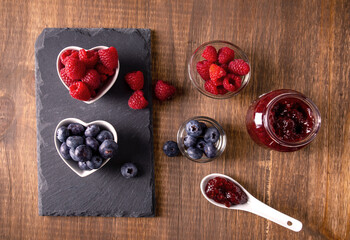 raw French in a heart bowl with strawberry jam in a spoon seen from above