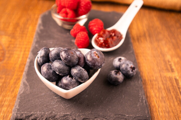 Raw organic blueberries in a heart bowl with strawberry jam
