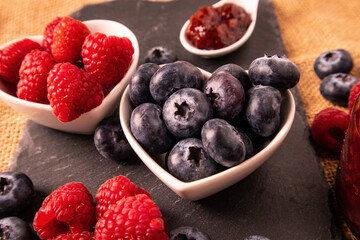 Raw organic blueberries in a heart bowl with strawberry jam
