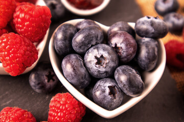 Blueberries and raspberries bowl on wooden table