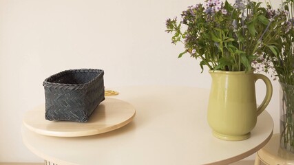 Adornos en la mesa. Cesta verde y jarrón con flores