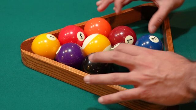 Man Adjusts, Messes and Fiddles with 9 Ball Pool Diamond Rack and Tightens Balls with Hands before Lifting Wooden Triangle on the Spot Closeup on a Table with Green Felt or Cloth