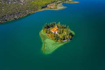 Fototapeta na wymiar Visovac, Christian monastery, Croatia. Little island on river Krk in National Park Krk. Aerial drone shot in september 2020
