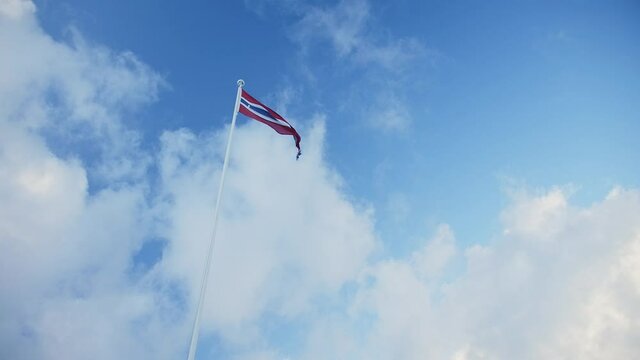 Norwegian flag, winter clouds in Aalesund, Norway.