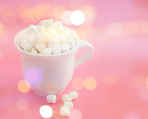 Fototapeta na wymiar Sweet marshmallows in a white cup with and bright bokeh background. Holiday and food concept.