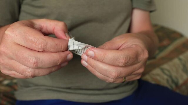 Opening up of and application of cleaning the abdomen with a wet hygiene disinfectant wipe in preparation to self apply medicine at home through a medical needle pen injecting the substance