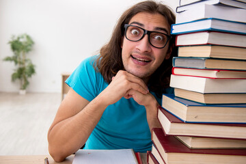 Young male student and a lot of books in the class