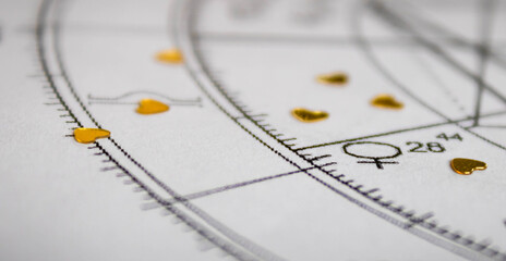 Detail of printed astrology chart with Venus planet and golden  heart shaped sequins