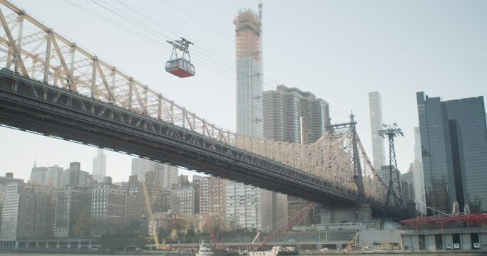 Tiltup shot from the Roosevelt Island coast revealing the tramway traveling overhead