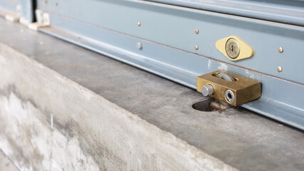 Metal roller door lock padlock. The corrugated steel rolling door is locked by a brass padlock with...
