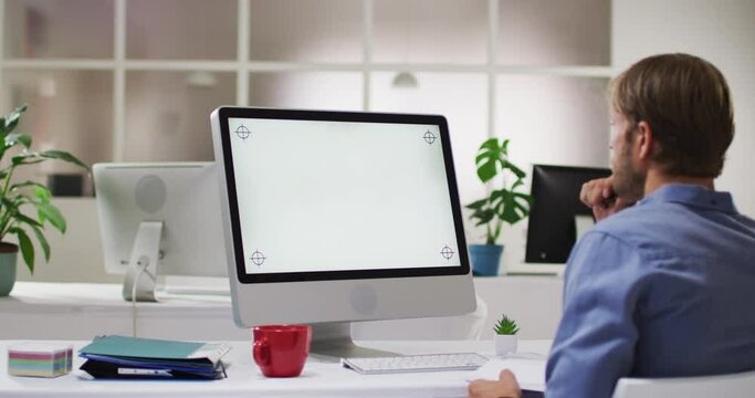 Caucasian man using computer while sitting on his desk at office