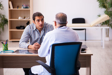 Young male patient visiting aged male doctor