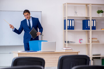 Young male business trainer in the office during pandemic