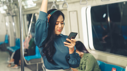 Young woman mobile phone on public train . Urban city lifestyle commuting concept . © InfiniteFlow