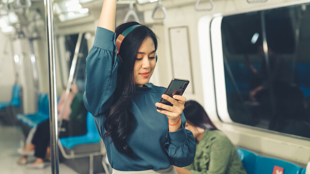 Young Woman Mobile Phone On Public Train . Urban City Lifestyle Commuting Concept .