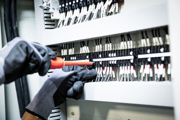 Electricians work to connect electric wires in the system, switchboard, electrical system in...