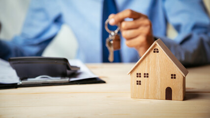 House model with real estate agent and customer discussing for contract to buy house, insurance or...