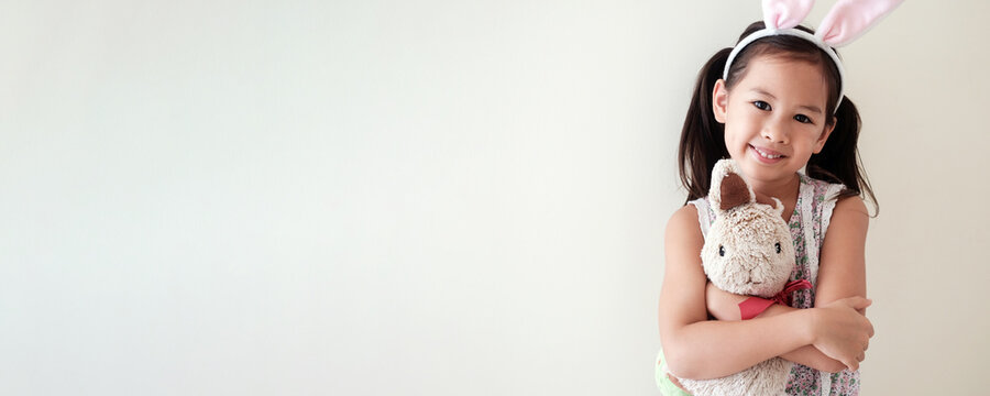 Happy little multicultural asain girl with bunny rabbit, Easter kid