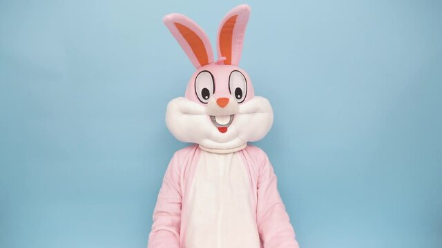 Positive funny man or kid singer or vocalist sings song to retro vintage classic microphone. Easter bunny or rabbit or hare celebrates Happy easter isolated on blue